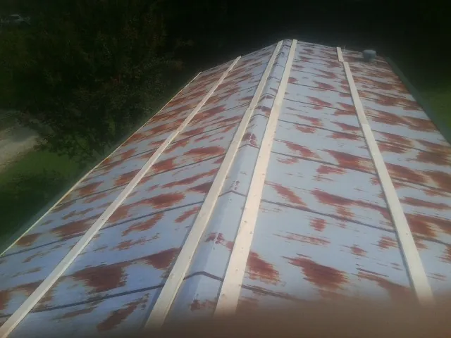 Rusted metal roof panels with new wood purlins before replacement — Storm Damage Roof Repair in Tecumseh by Roofing Brothers
